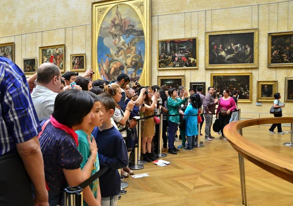 Paříž, Francie - 13 května 2015: Návštěvníci fotit Leonardo Davinci "Mona Lisa" v muzeu Louvre — Stock fotografie