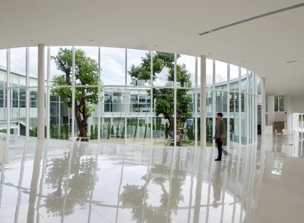 Glass wall in the building with people walking in motion blur — Stock Photo, Image