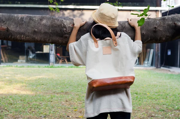 Jeune femme tenant branche banyan avec un sac en toile — Photo