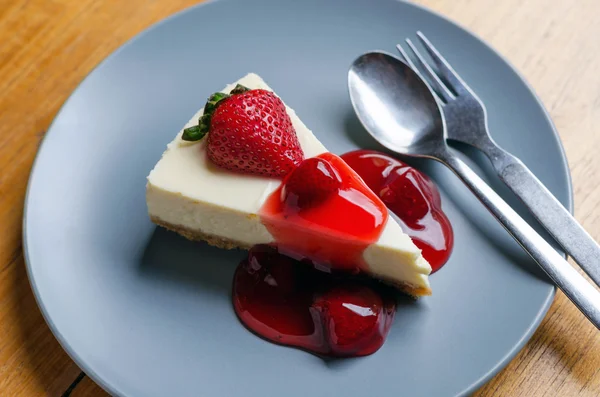 Strawberry cheesecake met lepel en vork op houten tafel — Stockfoto