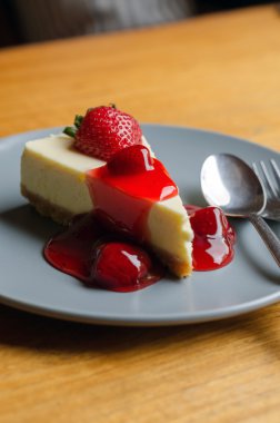 kaşık ve çatal ile çilekli cheesecake 