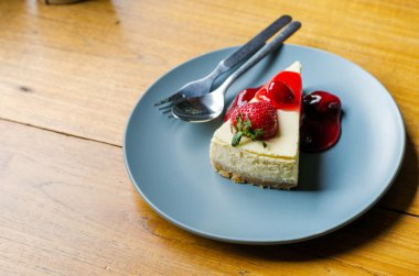 ahşap masa üzerinde çilekli cheesecake