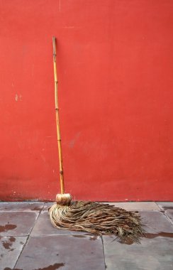 Mop lean against red wall clipart