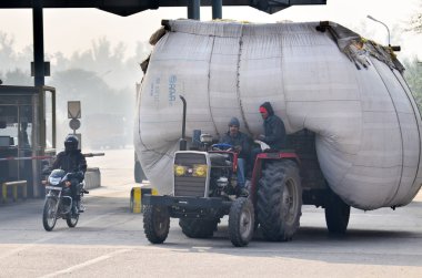 Jaipur, Hindistan - 30 Aralık 2014: Jaipur bölgesinde yoğun olarak aşırı yüklü kamyon sürüş Hintli adam,