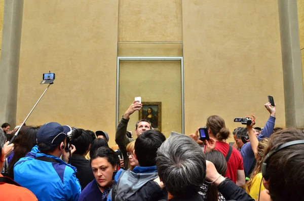 Paříž, Francie - 13 května 2015: Návštěvníci fotit Leonardo Davinci "Mona Lisa" v muzeu Louvre — Stock fotografie