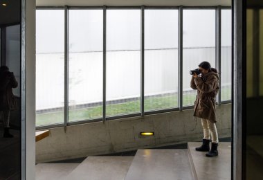 binanın içinde DSLR fotoğraf makinesi kullanan kadın