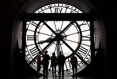 Paris, France - May 14, 2015: Silhouettes of unidentified tourists looking through the clock in the museum D'Orsay.