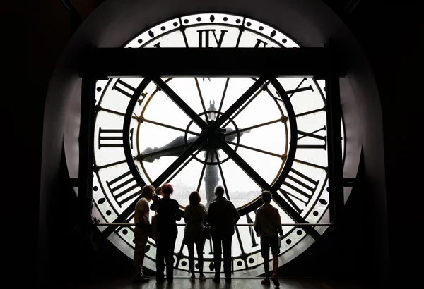 Paris, France - May 14, 2015: Silhouettes of unidentified tourists looking through the clock in the museum D'Orsay. — Stockfoto