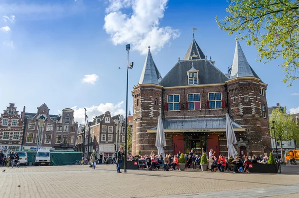 Ámsterdam, Países Bajos - 7 de mayo de 2015: La gente visita The Waag en la plaza Nieuwmarkt en Ámsterdam . — Foto de Stock