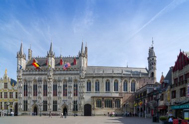 Bruges, Belgium - May 11, 2015: Tourist on Burg square with City Hall and Basilica of the Holy Blood in Bruges
