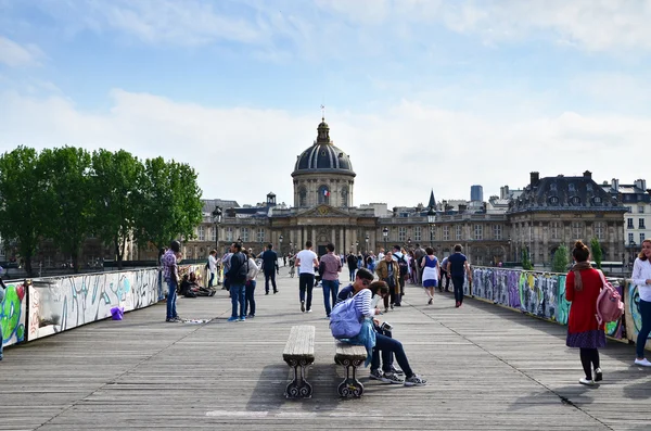 Paris, France - May 13, 2015: People visit Institut de France and the Pont des Arts or Passerelle des Arts bridge — Stock Photo, Image