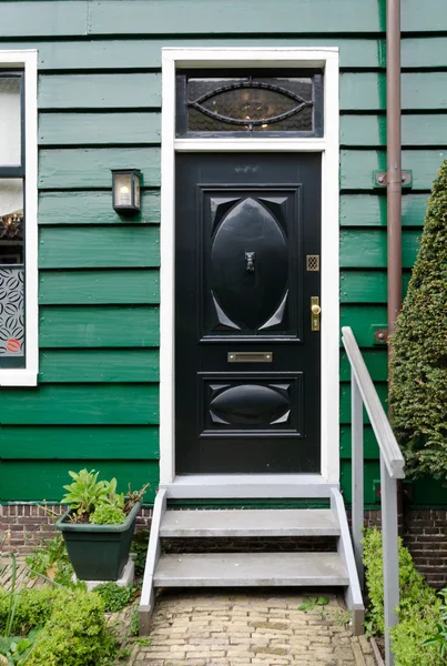 Porte en bois noir wth maison murale verte — Photo