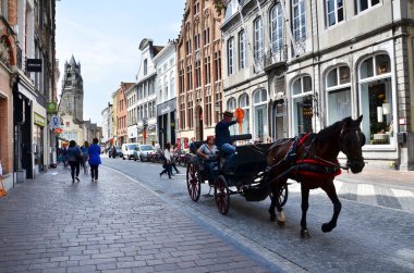 Bruges, Belçika - 11 Mayıs 2015: Turist şehirde geleneksel at arabası içinde Bruges ziyaret.