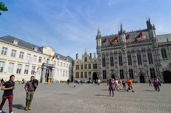 Brujas, Bélgica - 11 de mayo de 2015: Turista en la plaza Burg con Ayuntamiento de Brujas — Foto de Stock