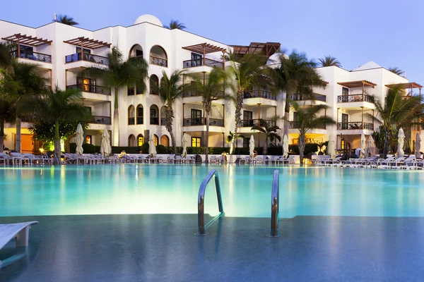 黄昏时设有游泳池的豪华酒店 免版税图库图片