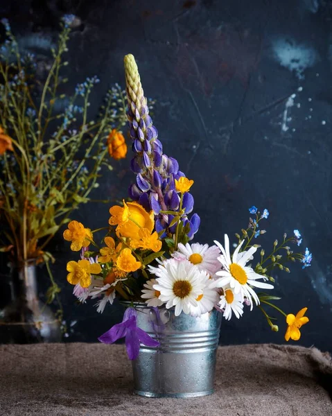 Small bouquet of lupines and charmolines in a bucket — Stock Photo, Image