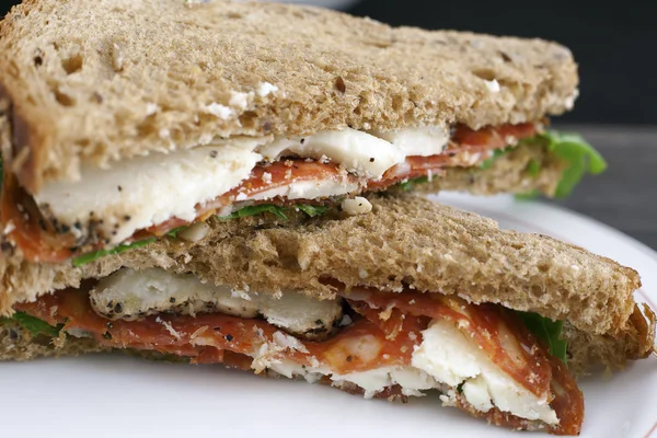 Ιταλική σαλάμι και πρόβατα τυρί σάντουιτς με μαύρο ψωμί. — Φωτογραφία Αρχείου