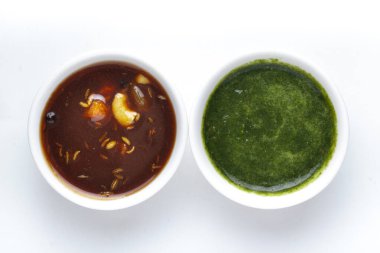 Yakın plan mango kuru meyveler tatlı kırmızı koyu turşu ve yeşil kişniş aklı beyaz seramik kasede baharatlı turşu..