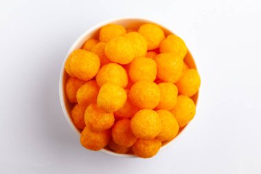 Peynirli Patates Toplu Atıştırmalıkları, ekşi turuncu renkler, Kıtır kıtır ve poğaça yemeye hazır, beyaz arka planda beyaz seramik kasede tuzlu