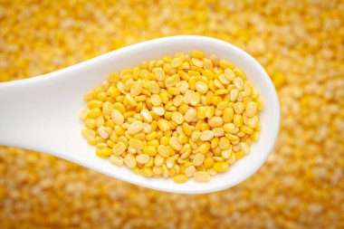 Organik sarı Gram 'ın (Vigna radiata) Macro Close' u ya da bulanık arkaplanda seramik beyaz çorba kaşığının içinde sarı moong dalını ayırmak. Üst görünüm