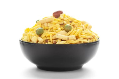 Fıstık, şeker, kuru üzüm ve besan sev ile yapılmış siyah seramik bir kasede lezzetli Khatta Meetha. Hint baharatlı atıştırmalıkları (Namkeen)