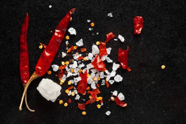 Siyah arka planda kırmızı biber ve baharatlar.