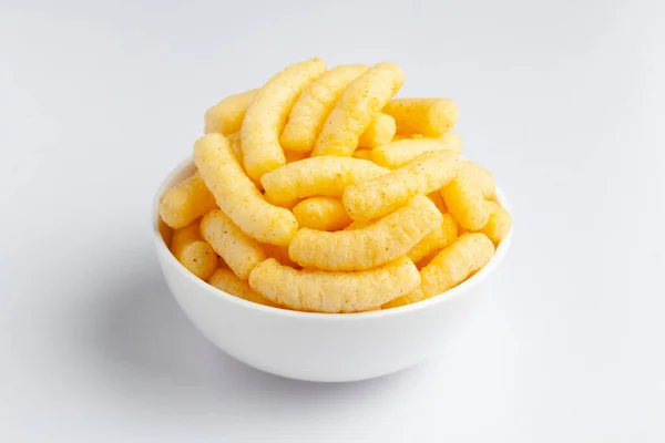 Close up of Cheese Potato Puff Snacks sticks, Popular Ready to eat crunchy and puffed snacks sticks  cheesy salty pale-yellow color over white background