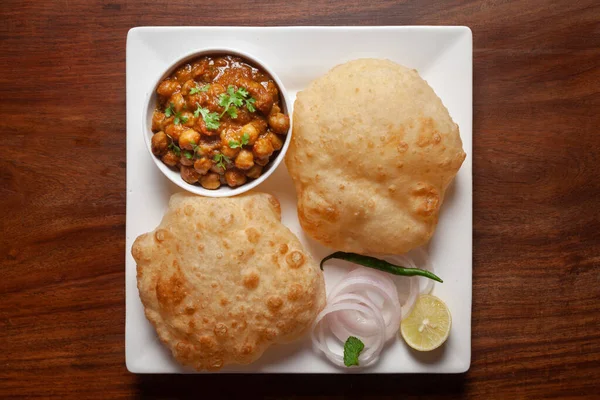 Nohut masala (baharatlı chola veya chhole curry) ve taze yeşil kişniş ve malzemelerle süslenmiş Bhatura veya Puri. Klasik bir Hint yemeği. Tipik Panjabi sokak yemeği..