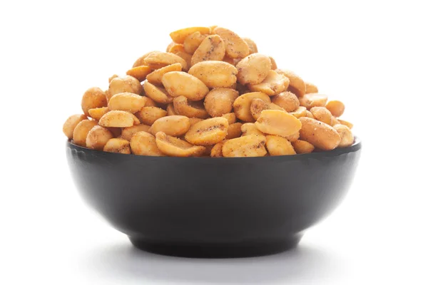 Seramik siyah bir kase üzerinde kıtır kıtır masala fıstıklarına yakın durun..