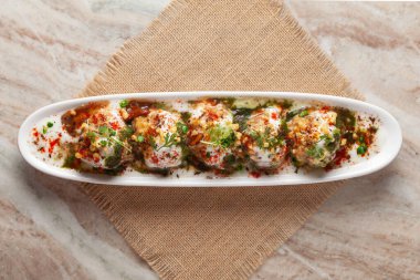 Chaat Dahi Vada (diğer adıyla Dahi Bhalla, Doi Bora, mosaru vade, Dahi Bara, thayir vadai, perugu vada). Yoğurt (yoğurt) ile ıslatılmış vadas tarafından hazırlanır. Kimyon ve yeşil kişniş ile süslenmiş.