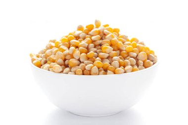 Beyaz bir seramik kasenin içine organik sarı mısır tohumu ya da mısır tohumunu (Zea mays) kapatın