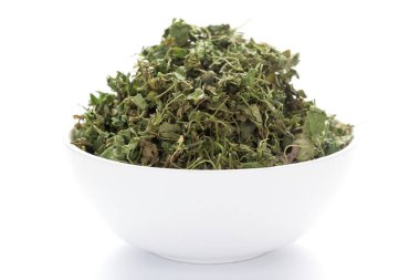 Seramik beyaz bir kase üzerinde organik yeşil Fenugreek yapraklarının (Trigonella foenum-graecum) yakın çekimi. Hint Aromatik Baharatı Yığını