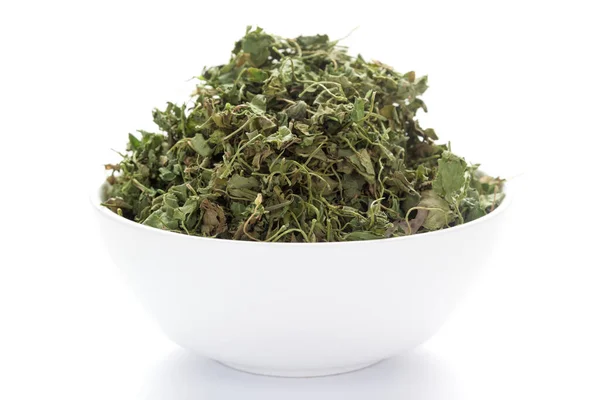 Seramik beyaz bir kase üzerinde organik yeşil Fenugreek yapraklarının (Trigonella foenum-graecum) yakın çekimi. Hint Aromatik Baharatı Yığını