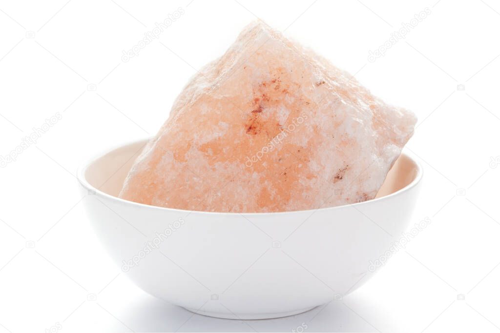 Close-up of coarse Himalayan Pink Salt (sodium chloride) edible on the white ceramic bowl.