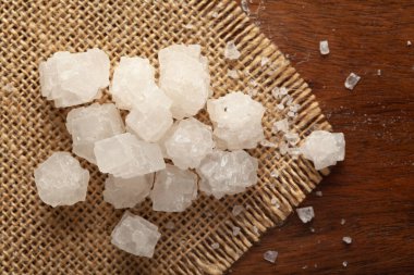 Kaba deniz tuzu (sodyum klorür) yakın plan ahşap arka plan ve jute mat yenilebilir.