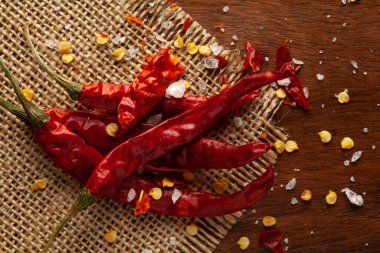 Ahşap arka plan ve jüt paspasın üzerinde organik kırmızı biber (Capsicum annuum) yakın plan Macro. Hint Aromatik Baharatı Yığını. Üst görünüm