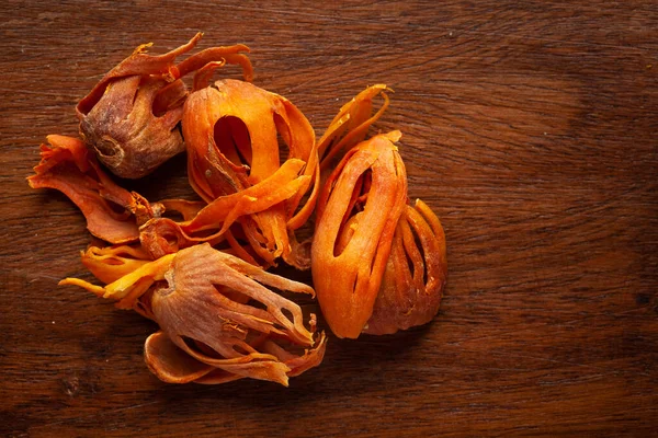 Macro close-up of Organic mace  (Myristica fragrans) on wooden top background. Pile of Indian Aromatic Spice. Top view