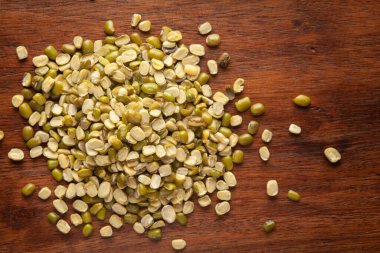 Organik yeşil Gram 'ın (Vigna radyatör) makro yakın çekimi veya ahşap arka planda cilalanmamış yeşil moong dalının dökülmesi.