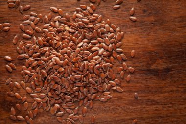 Organik kahverengi keten tohumu (Linum usitatissimum) veya ahşap arka planda temizlenmiş keten tohumu.