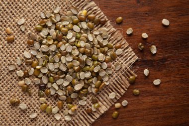 Organik Parlatılmamış Yeşil Gram 'ın (Vigna radyatör) Makro Yakın Çekimi veya Yeşil Moong Dal' ın Jute minderi ve ahşap kaplaması.