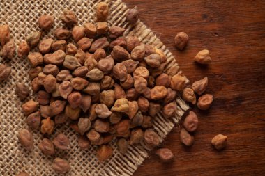 Organik chana veya nohut (Cicer arietinum) makro yakın çekim veya tüm beyaz Bengal gramı Jute minder ve ahşap üst.
