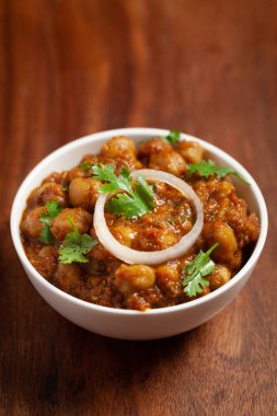 Taze yeşil kişniş ve malzemelerle süslenmiş nohut masalası (baharatlı köri veya chole). Klasik bir Hint yemeği. Tipik Panjabi sokak yemeği..