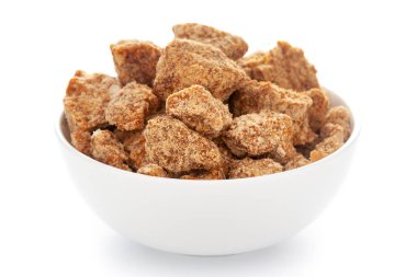 Beyaz zemin üzerinde beyaz seramik kâse içinde şeker kamışı jaggery parça yakın plan