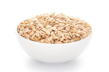 Beyaz arka plan üzerinde beyaz seramik kasede organik karpuz tohumları yakın plan