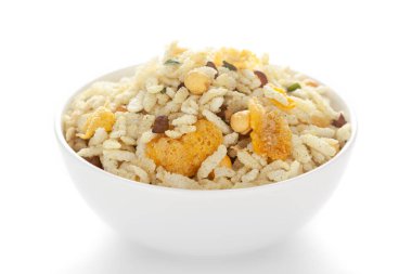 Puff Rice, Corn Flakes ve Curry yapraklarından yapılmış beyaz seramik bir kasede Çıtır Diyet Karışımı. Hindistan baharatlı çerez yığını (Namkeen), arka plan ışığı altında, yan görünüm, beyaz arka plan karşı.