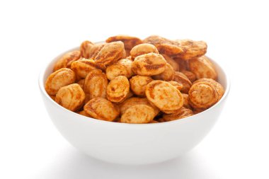 Fıstıkla yapılmış beyaz bir seramik kasede kavrulmuş fıstık. Hindistan baharatlı çerez yığını (Namkeen), arka plan ışığı altında, yan görünüm, beyaz arka plan karşı.