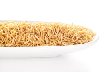 Beyaz bir seramik oval kasede tuzlu bir düzlem olan Bhujia, nohut veya gram undan (Besan) yapılır. Hindistan tuzlu çerez yığını (Namkeen), arka plan ışığı altında, yan görünüm