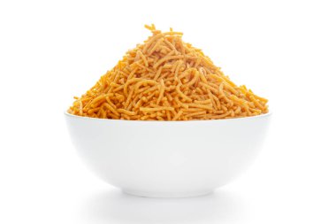 Kırmızı biber, patates ve nohut ile yapılan beyaz bir seramik kasede baharatlı Aloo Bhujia. Hindistan baharatlı abur cubur yığını (Namkeen), arka plan ışığı altında, beyaz arka plan karşı cephe manzaralı.