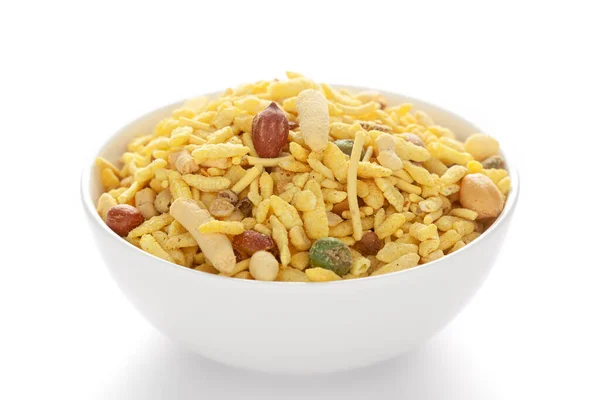 Fıstık, şeker, kuru üzüm ve besan sev ile yapılmış beyaz seramik bir kasede lezzetli Khatta Meetha. Hindistan baharatlı çerez yığını (Namkeen), arka plan ışığı altında, yan görünüm, beyaz arka plan karşı.
