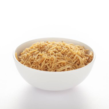 Hint baharatlı atıştırmalıkları (Namkeen) - Bikaneri Besan Bhujia beyaz bir kase içinde, nohut unundan (Besan) yapılmış, kenar manzaralı, beyaz arka planda.